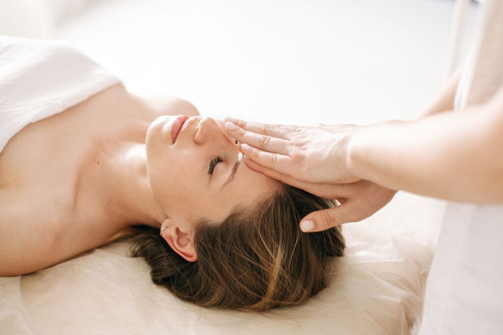 Femme allongée les yeux fermés dans un état de profonde relaxation pendant un soin bien-être