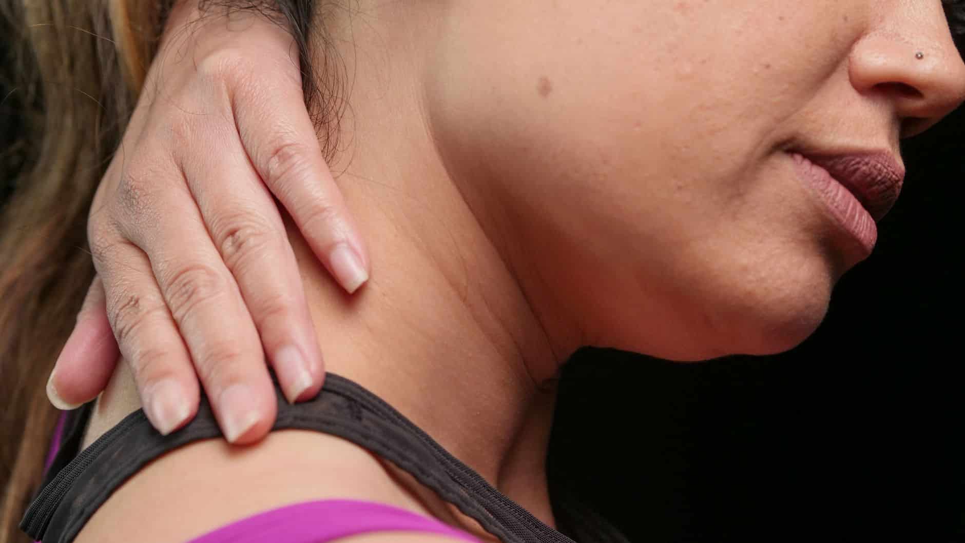 Femme assise, les épaules contractées et la nuque tendue, illustrant les tensions physiques ressenties à la rentrée de septembre